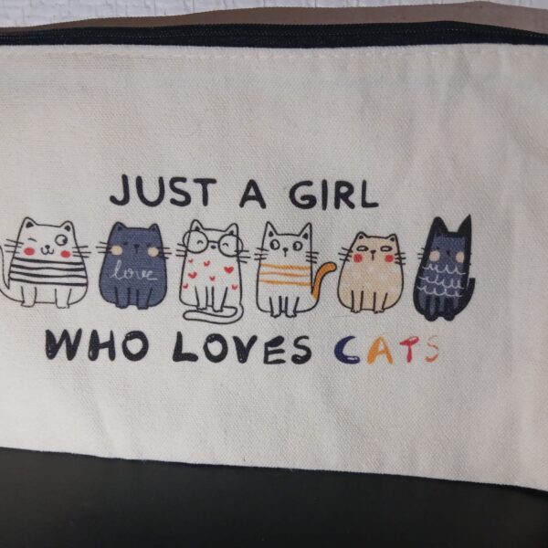 Pochette écrue à fermeture éclair noire, illustrée de six chats avec l’inscription « Just a girl who loves cats ».