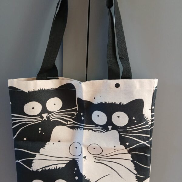 Sac beige et noir à motifs de chats.